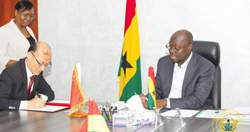Dr Cassiel Ato Forson (right), Minister of Finance, and Tong Defa (left), outgoing Chinese Ambassador to Ghana, signing the MOU
