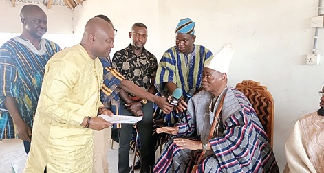 Charles Puozing (left), Upper West Regional Minister, receiving the petition from Kuoro Baduawaali (right) during a visit to his palace at Welembelle in Sissala East 