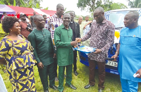 Henry Theodore Sintim, the District Director of Education, handing over the keys and other documents of the vehicle to Eric Afari-Agyapong at the ceremony