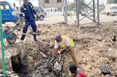 Adamu Musa Kalamu (arrowed), MCE for Ablekuma North, helping to clear filth in a choked drain during the exercise