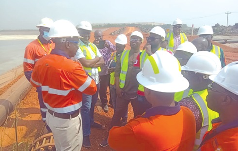 Dr Charles Amoah(left), Managing Director, Asanko Gold Mine, explaining a point to the committee during a tour of the mine's dam