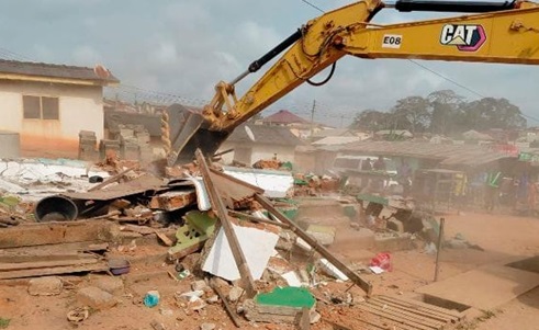 An excavator clearing some debris from the project site 