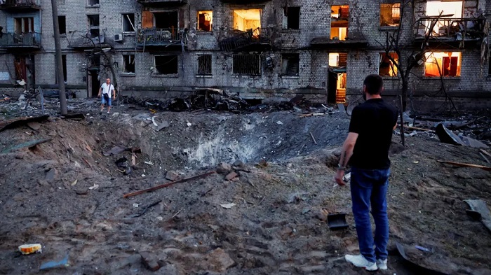 Explosions formed a crater next to bombed-out buildings in Kyiv