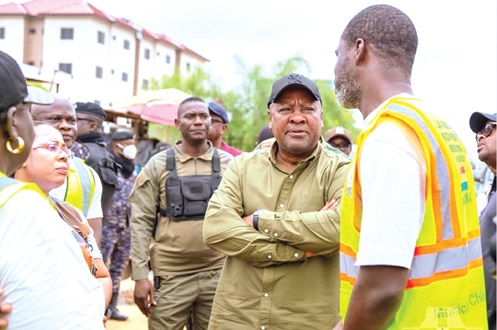 President John Dramani Mahama (2nd from right), interacting with a worker during the cleaning exercise. Looking on are some dignitaries