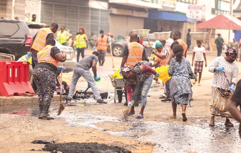 Police officers assist sanitation workers in desilting a  storm drain during the clean-up at Accra Central, demonstrating inter-agency collaboration to improve sanitation and help prevent flooding. Pictures: CALEB VANDERPUYE