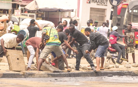 Residents and volunteers remove heavy concrete slabs and debris from a choked drain during the clean-up exercise at the Kwame Nkrumah Circle in Accra to improve drainage