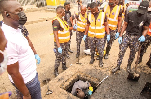 Personnel from Zoomlion Ghana Limited, supported by community members, swept and cleared silt and waste from sections of the road during the clean-up exercise at Accra Central