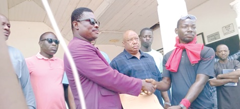 Albert Dok Dong (right), one of the convenors of the demonstration, presenting the petition to Francis Yenwona Tobig (left), the Nabdam District Chief Executive (DCE), while others look on 