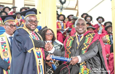 Dr Julius Debrah (right), the Chief of Staff, receiving his PhD during the graduation ceremony at the University of Ghana, Legon