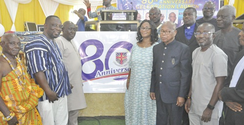 Prosper Dusey (3rd from left), Ho West DCE; Dr Dickson Tsey (2nd from left), Principal of AMECO, and other stakeholders by the 80th anniversary logo