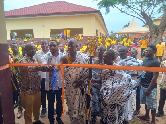 Mr Eddy Nartey (2nd left) Head of Business  at Nyonkopa Cocoa Buying Limited assisting Dr Isaac Manu (left) Director, Research Unit, COCOBOD and Nana Amuagjaafo (2nd from right) to cut the tape to inaugurate the classroom block.