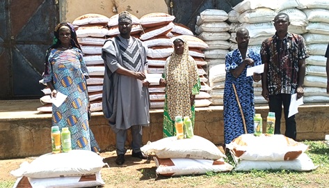 Adam Abdul Hafiz, (2nd from left), Municipal Chief Executive for Gushegu, presenting items to a beneficiary. With them are other beneficiairies