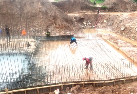 Workers on site busily constructing the Sataso bridge before its destruction by the heavy downpour