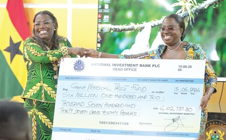 Nana Oye Bampoe Addo (left), Deputy Chief of Staff in charge of Administration, presenting the cheque to Adjoa Obuobia Darko-Opoku, Administrator of the Ghana Medical Trust Fund 