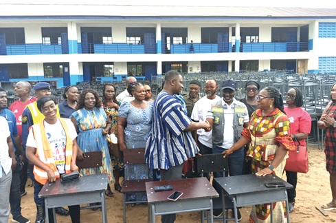 Dr Ernest Henry Norgbey, MP for Ashaiman, handing over the furniture to Freeman Tsekpo, MCE for Ashaiman, and Gloria Kwakuyi (right), Municipal Education Director for Ashaiman
