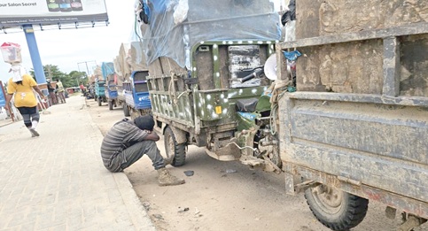 A tricycle rider taking a nap as hundreds of refuse carriers queue to access the dumping site A tricycle rider taking a nap as hundreds of refuse carriers queue to access the dumping site