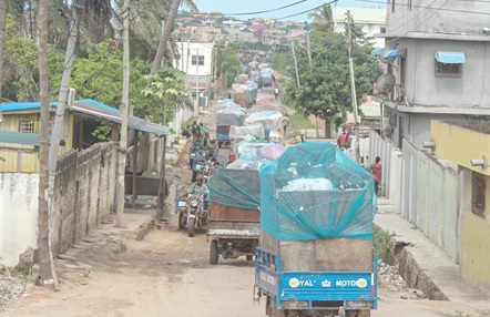 A queue of tricycles awaiting their turn in an alley towards the dumpsite