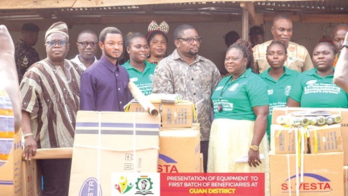 Fred Agbenyo (middle, front row), presenting the items to Augustina Agbodza (3rd from right), a master craftswoman, during the ceremony. On the left is Michael Mampah, the NAP Regional Coordinator, and Godfried Kofie Dukormevi, the DCE of Guan