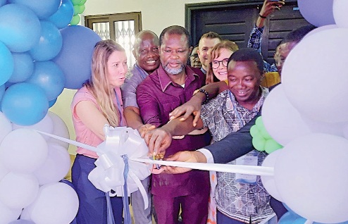 Dr Ignatius Awinibuno (3rd from left), Director, Allied Health, Ministry of Health, being assisted by Prof. Bernard Asimeng (right) HOD, Biomedical Engineering, Dr Helen Widmer (2nd from right), Project Coordinator, GIZ, and other dignitaries to cut the ribbon to officially launch the laboratory. Picture: ERNEST KODZI