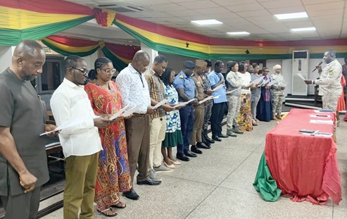 Dennis Nartey (right), Greater Accra Regional Director of the NADMO, swearing in the members of Tema Metropolitan Disaster Management Committee