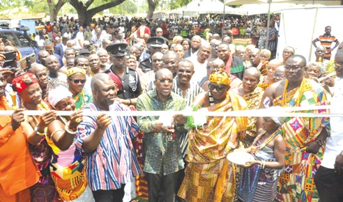 Alban Bagbin (middle), Speaker of Parliament, being assisted by Togbega Addai Kwasi XIII, Paramount Chief of Awudome, and James Gunu (in smock), Volta Regional Minister, to cut the tape to open the Awudome Traditional Council office building