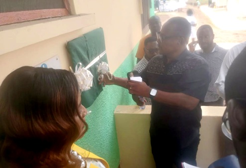 Felix Felix Akwetey Okle (with mic), Member of Parliament for Bortianor Ngleshie Amanfro, inaugurating the facility at the Bortianor Polyclinic.