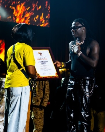 Stonebwoy (right) receiving the Certificate of Appreciation from Grace Hunu