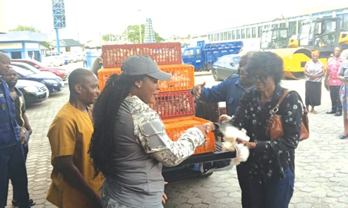 Ebi Bright (middle), MCE for Tema, handing over a chick to Gladys Galley, a beneficiary of the programme. With them is George Batse, Tema Metropolitan Director of Agriculture