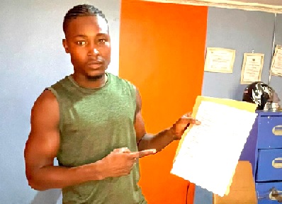 Sampson Segbedzi displays the fight contract after signing to fight Henry Malm on May 8