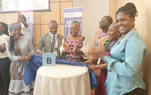 Emelia Arthur (4th from right), Minister of Fisheries and Aquaculture Development, being assisted by Jacob Adzikah (2nd from left), CEO, Chamber of Aquaculture Ghana; Dr Henry Anim-Somuah (3rd from right), Board Chairman of the Chamber, and Alberta Nana Akyaa Akosa (left), National Lead of World Food Forum Ghana, to unveil the logo for the Food Innovation Hub