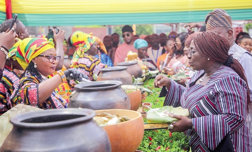 Abla Dzifa Gomashie (right), Minister of Tourism, sampling some Ghanaian dishes at the event