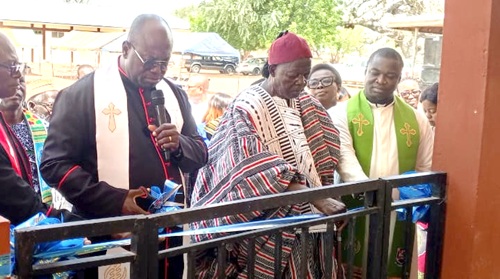 Rt Rev. Dr Abraham Nana Opare Kwakye (left), the Moderator of the General Assembly of the Presbyterian Church of Ghana, being supported by Naba Kosomo Legbe Serum-Tinganbila-Legbe Goo (middle), the chief of Yorogo, to cut the tape