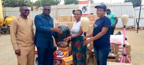 Emmanuel Addotey Allotey (2nd from left), Ga Central Municipal Chief Executive,  presenting hairdressing equipment to a beneficiary of the apprenticeship programme