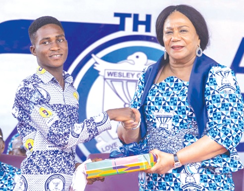 Rebecca Akufo-Addo (right), former First Lady, presenting an award to Richmond Ofoe, a former Science student of the School who had 8A1s  and currently pursuing Biomedical Engineering at KNUST
