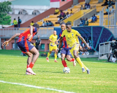  Kingsley Braye (right) of Medeama drives past two Eleven Wonders defenders as he surges into the Eleven Wonders half