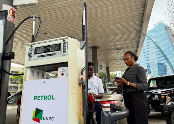 A customer stands beside a fuel attendant while buying petrol at an NNPC filling station, as fuel costs rise amid the U.S.-Israeli conflict with Iran, in Ikoyi, Lagos, Nigeria, March 9, 2026. REUTERS/Sodiq Adelakun/File Photo