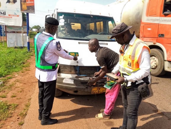 Officers inspecting and advising a driver to observe road safety protocols