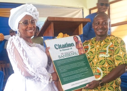 Grace Emefa Banibensu receiving her citation from an official of the Nkwanta North District Education Directorate.