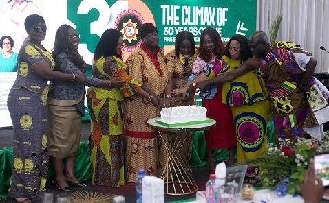 Daniella Mawusi Ntow Sarpong (4th from left), Chief Fire Officer, being supported by Patience Baffoe-Bonnie (left), Director-General, Ghana Prisons Service; Nana Oye Bampoe Addo (2nd from  left), Deputy Chief of Staff in charge of Administration; Agnes Naa Momo Lartey (3rd from left), Minister for Gender, Children and Social Protection; Linda Obenewaa Akweley Ocloo (2nd from right), Greater Accra Regional Minister, and other senior officers of the Ghana National Fire Service to cut the anniversary cake
