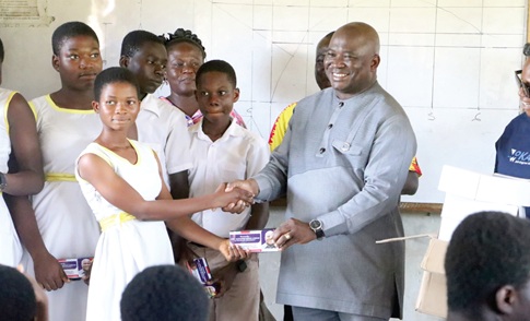Alexander Akwasi Acquah (right) presenting a mathematical set to one of the pupils while the others wait for their turn