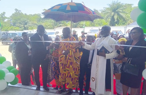 Prof. Francis Dodoo (left) assisting Barima Ogyeabour Amankwaah Adunan II (middle), the  Paramount Chief, Kuntanase Traditional Area, to cut the tape to inaugurate the office complex while other dignitaries look on