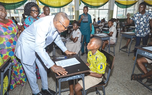 Dr Clement Apaak, Deputy Education Minister, interacting with one of the BECE candidates during his visits, while some officials from the ministry look on