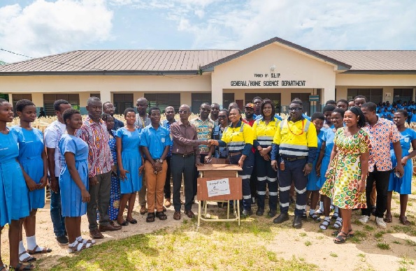 Mavis Nana Yaa Kyei,  the Social Development and Gender Superintendent, of AGA (middle) making a symbolic presentation of one of the desks to a representative