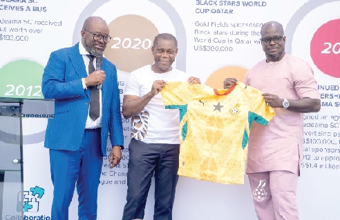 Former Black Stars captain and Vice-Chairman of the team’s management committee, Stephen Appiah (right), presents a Black Stars jersey to Gold Fields Ghana Managing Director Elliot Twum, as GFA President Kurt Simeon-Okraku looks on during the ceremony