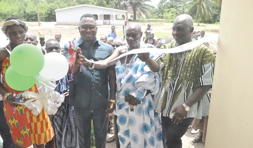 The three-unit nurses’ quarters of the Adaklu Ahunda-Boso Health Centre. Inset:  Jerry Yaw Ameko (3rd from right), being assisted by Togbe Asamoah IV (in cloth),  the Chief of Adaklu Ahunda-Boso, and Mathew Ayamba Adam, the Adaklu District Director of Health, to perform the tape-cutting ceremony