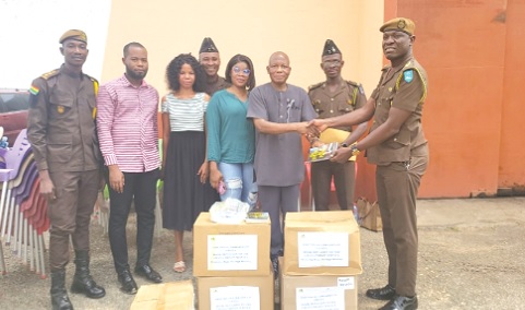 Peter Anafo, presenting a copy of a book to DPP Patrick Thomas Seidu of the Nsawam Prisons