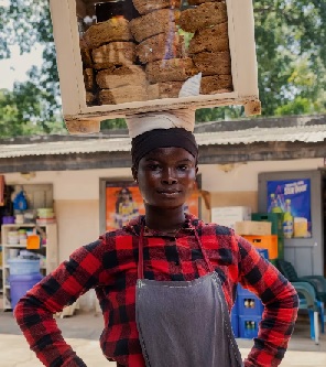 A young person balances a wooden box of freshly baked fried coconut dough, known as ‘poloo’. PHOTOS: Fiifi Abban