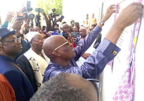 Haruna Iddrisu,  Minister of Education,  being assisted by officials of the NTC and GES to unveil the plaque