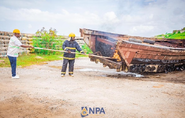 Godwin Edudzi Tamekloe (left), Chief Executive Officer of NPA, and a fire expert setting fire to the boats