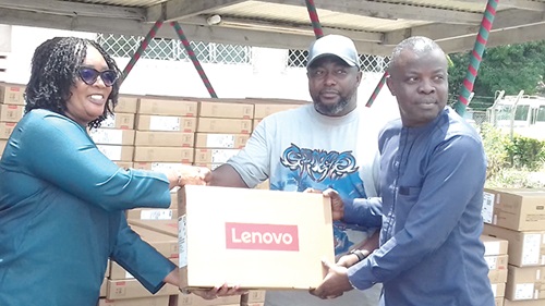 Rita Akosua Adjei Awatey (left), Eastern Regional Minister, presenting one of the laptops to Francis Addo Akumatey, Municipal Chief Executive for Yilo Krobo in Koforidua